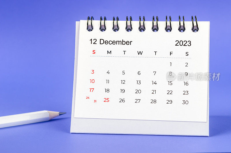 The December 2023 Monthly desk calendar for 2023 year with pencil on purple background.